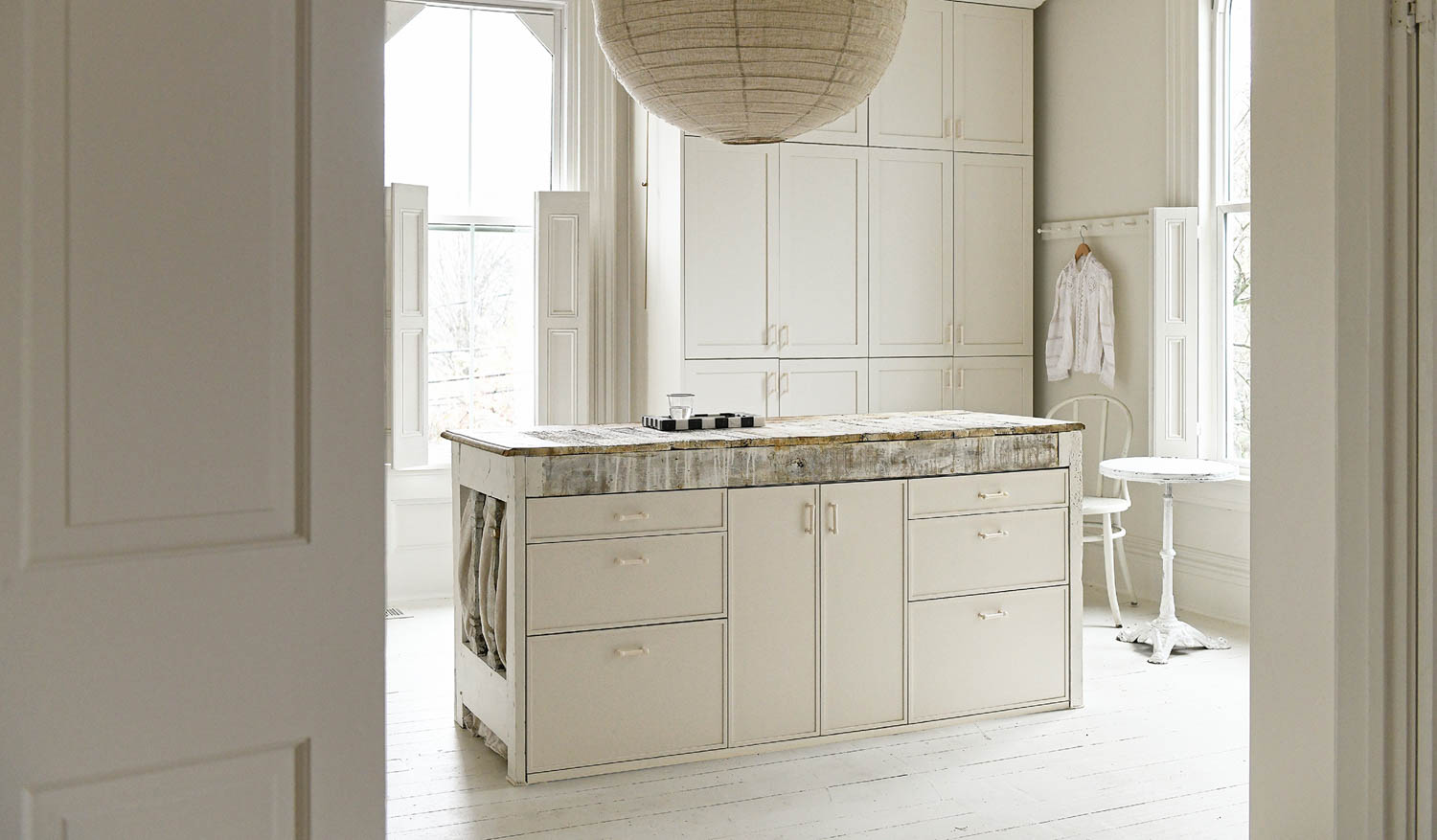 kitchen with all-white cabinets, lantern and flooring