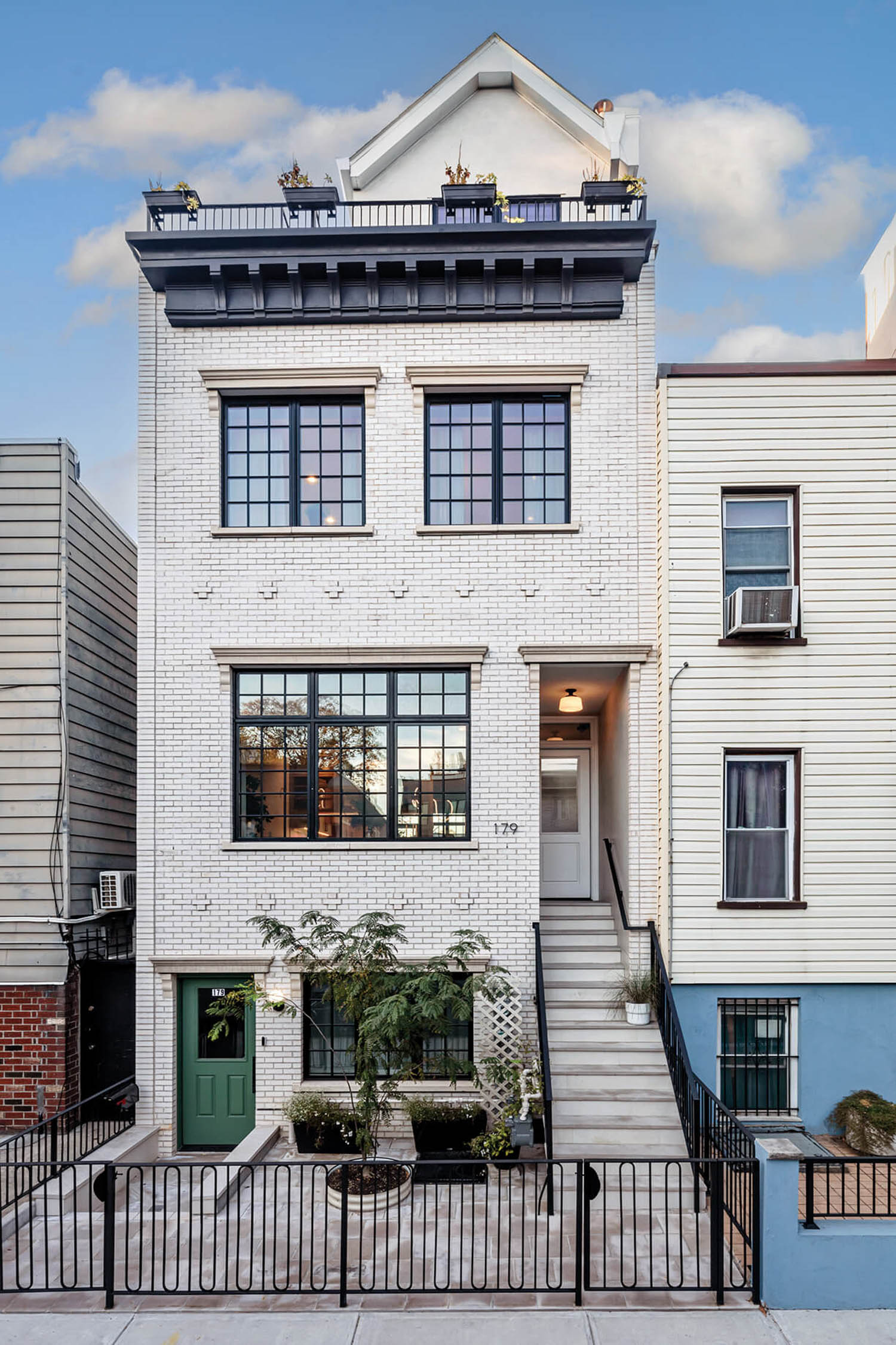 exterior facade of home in painted brick with a fence