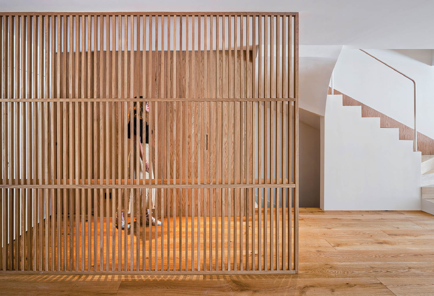 woman standing behind wooden partition panel