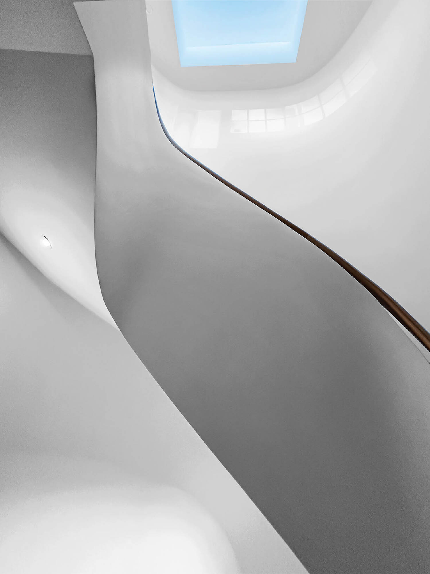 view of skylight and oak handrail and white walls