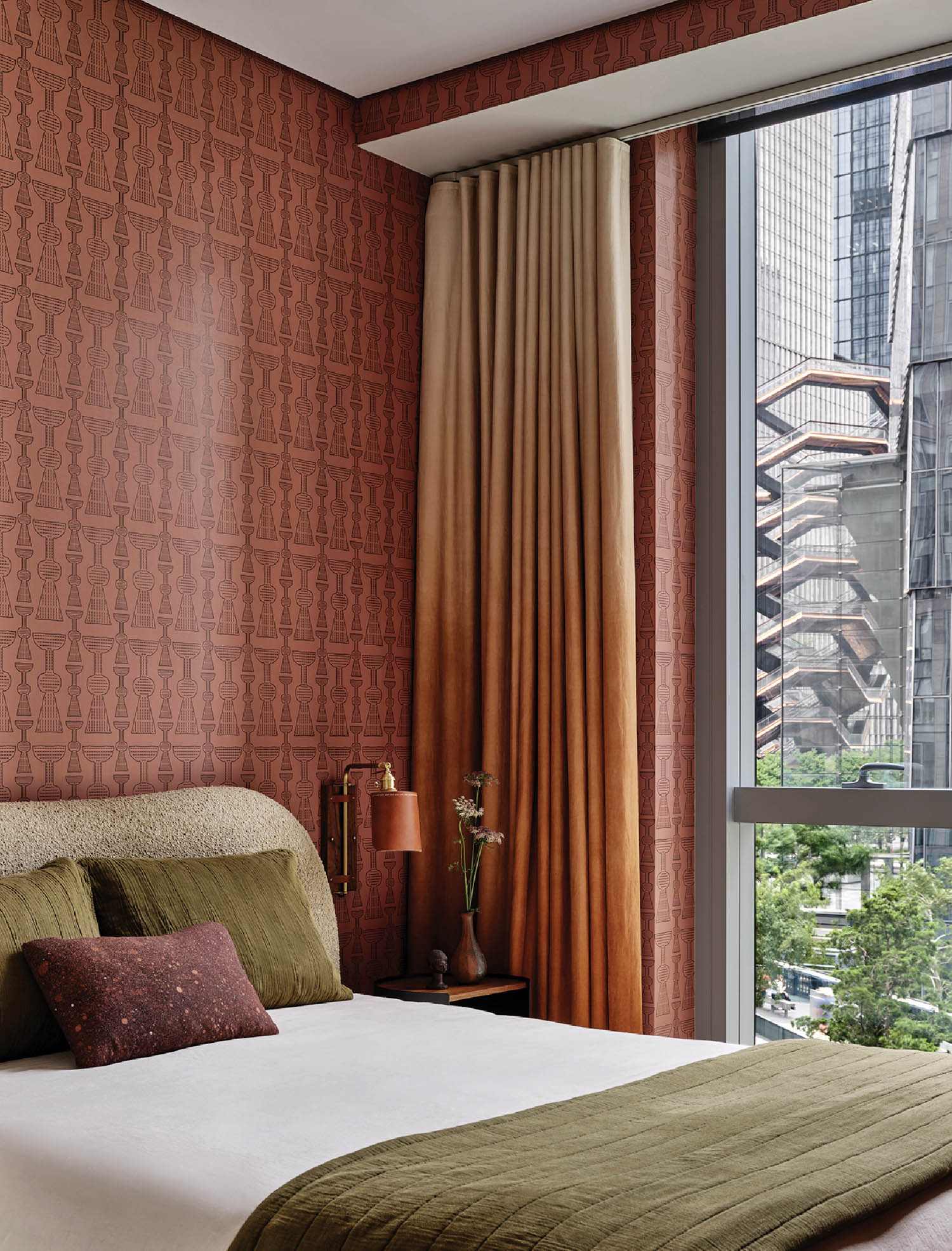 guest bedroom with clay colored wallcovering and olive green bed