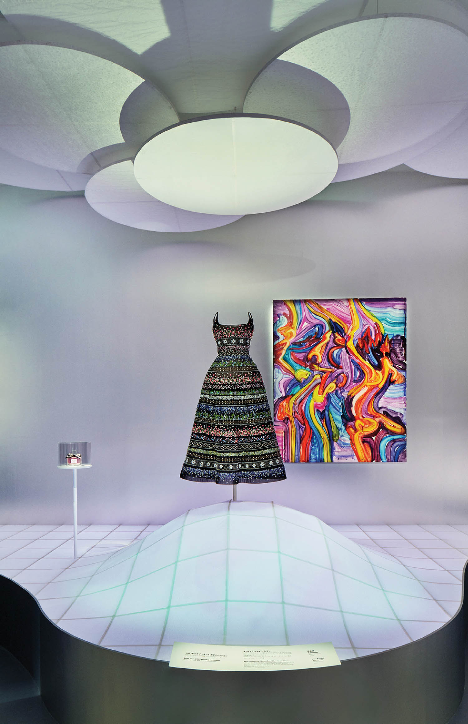 a patterned dress on a raised floor near bold artwork