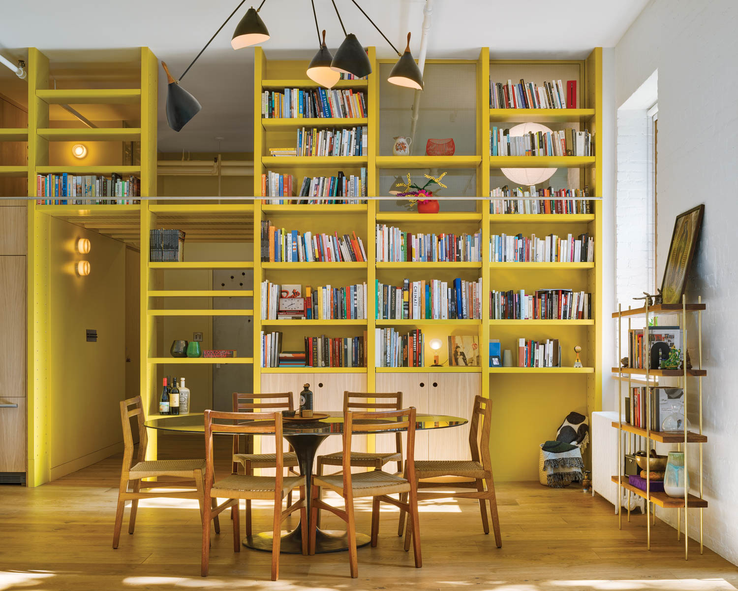 dining area with tall yellow bookshelves