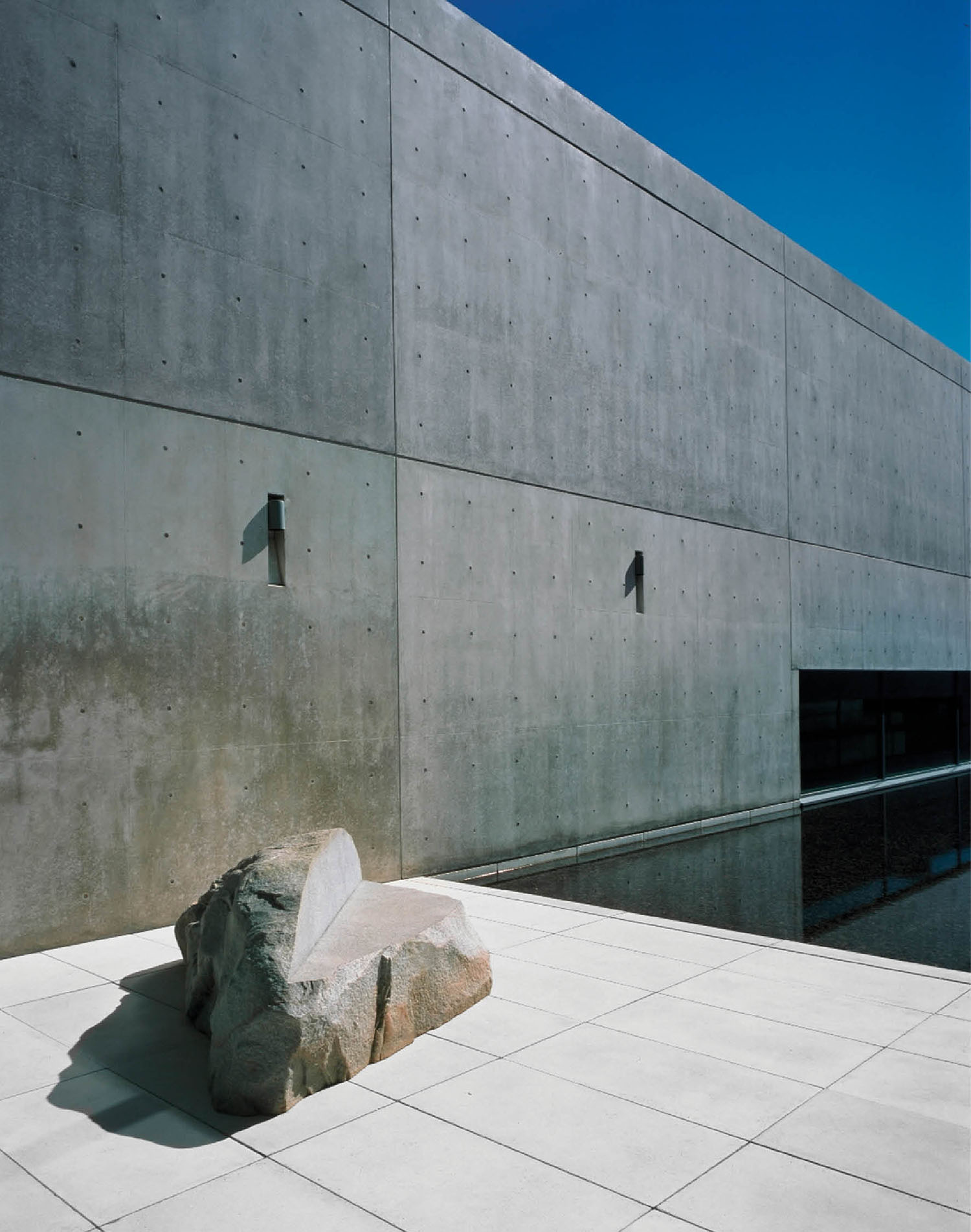 A large rock sitting on the ground next to a building