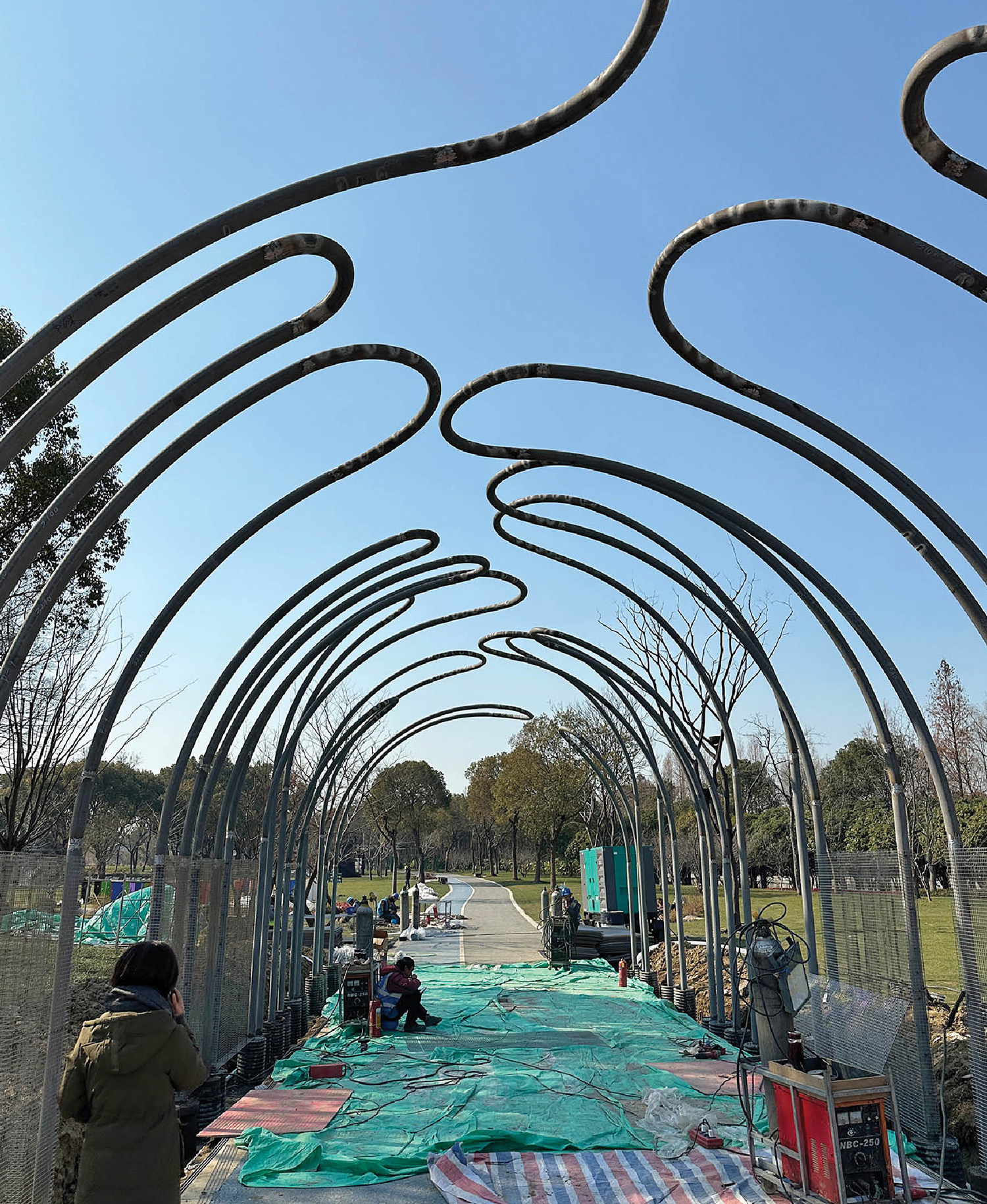 A man is standing under a metal structure