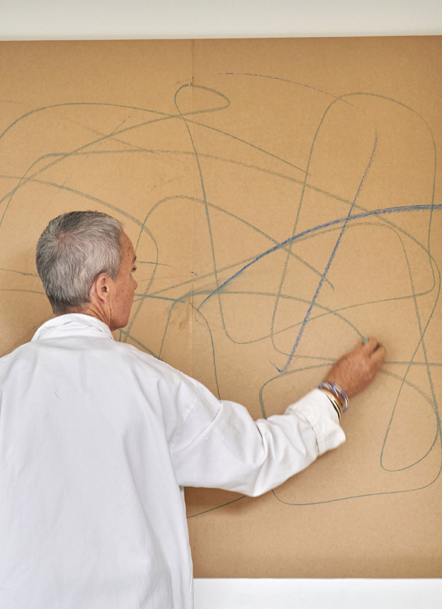 A woman is drawing on a wall