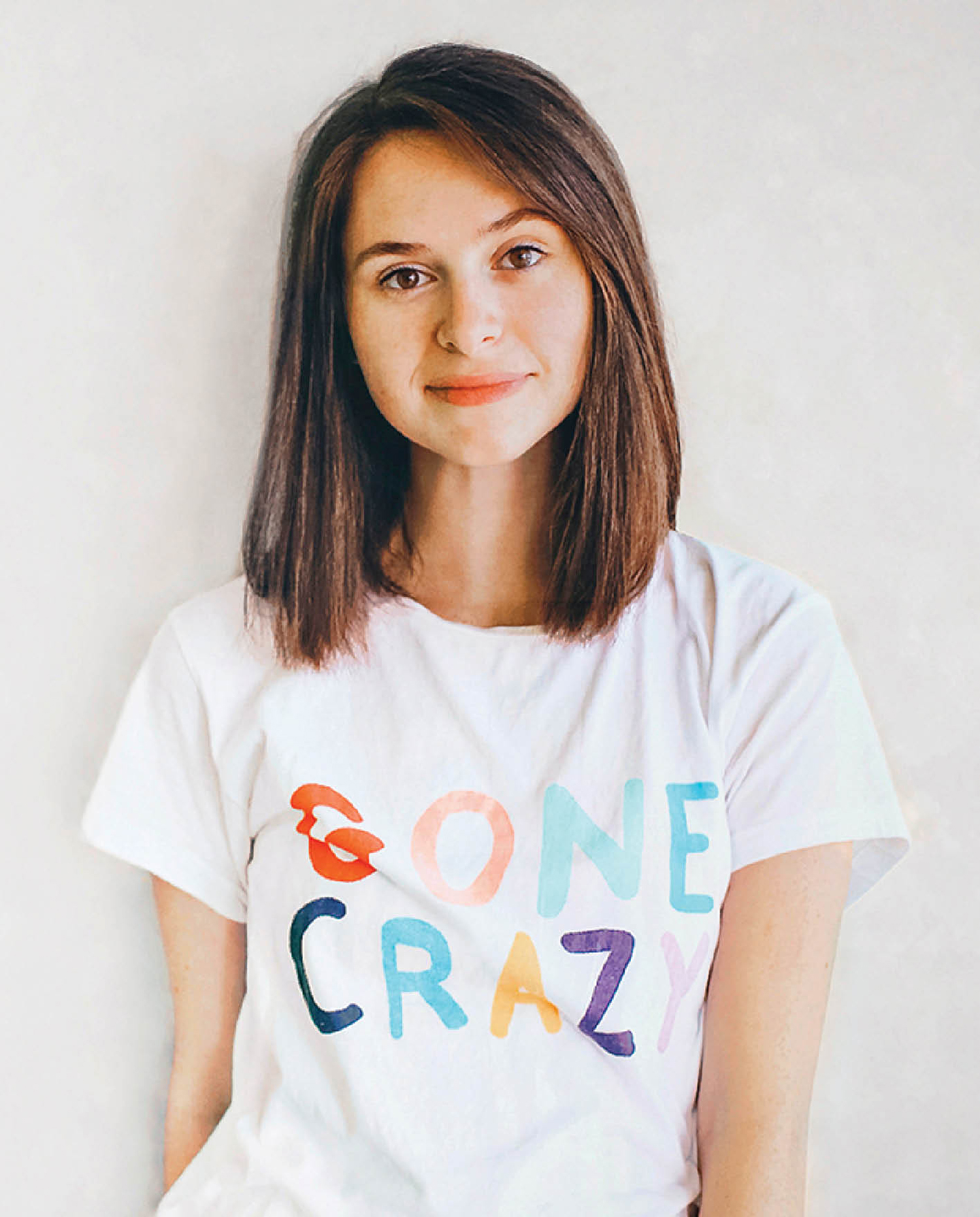 A woman wearing a white shirt with the word one crazy on it