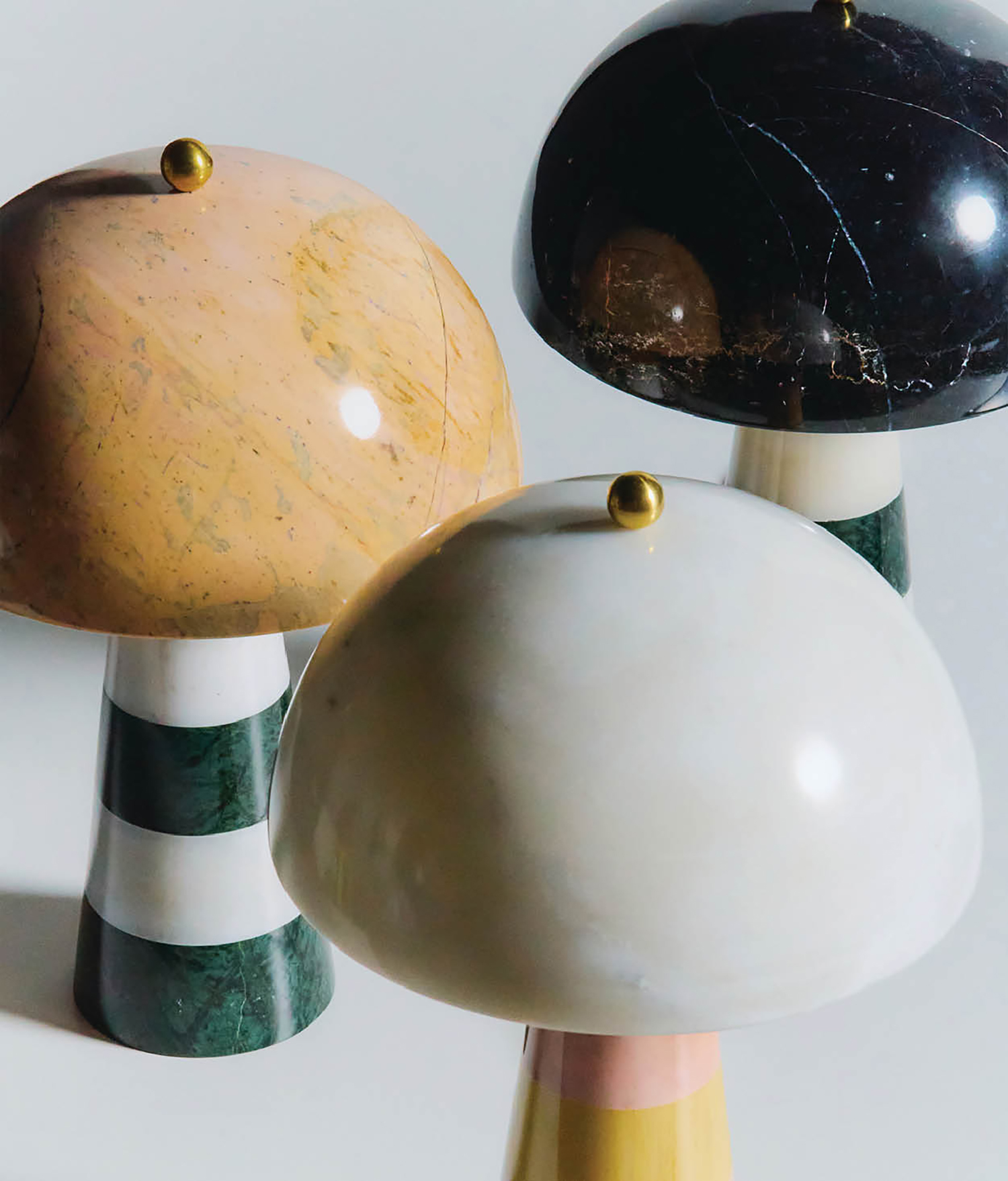 Three different colored marble lamps on a white background