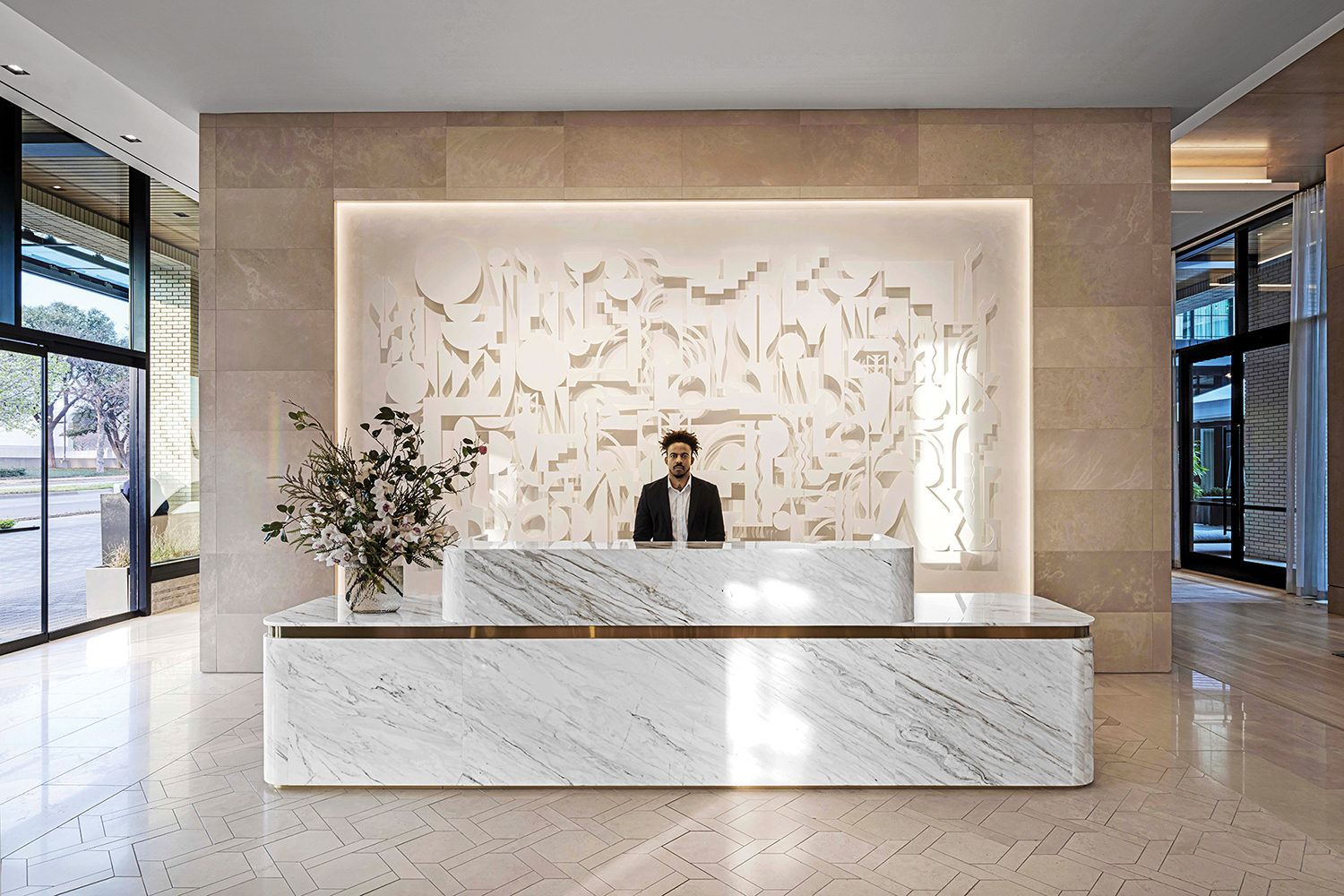 A white marble reception area with a lit background