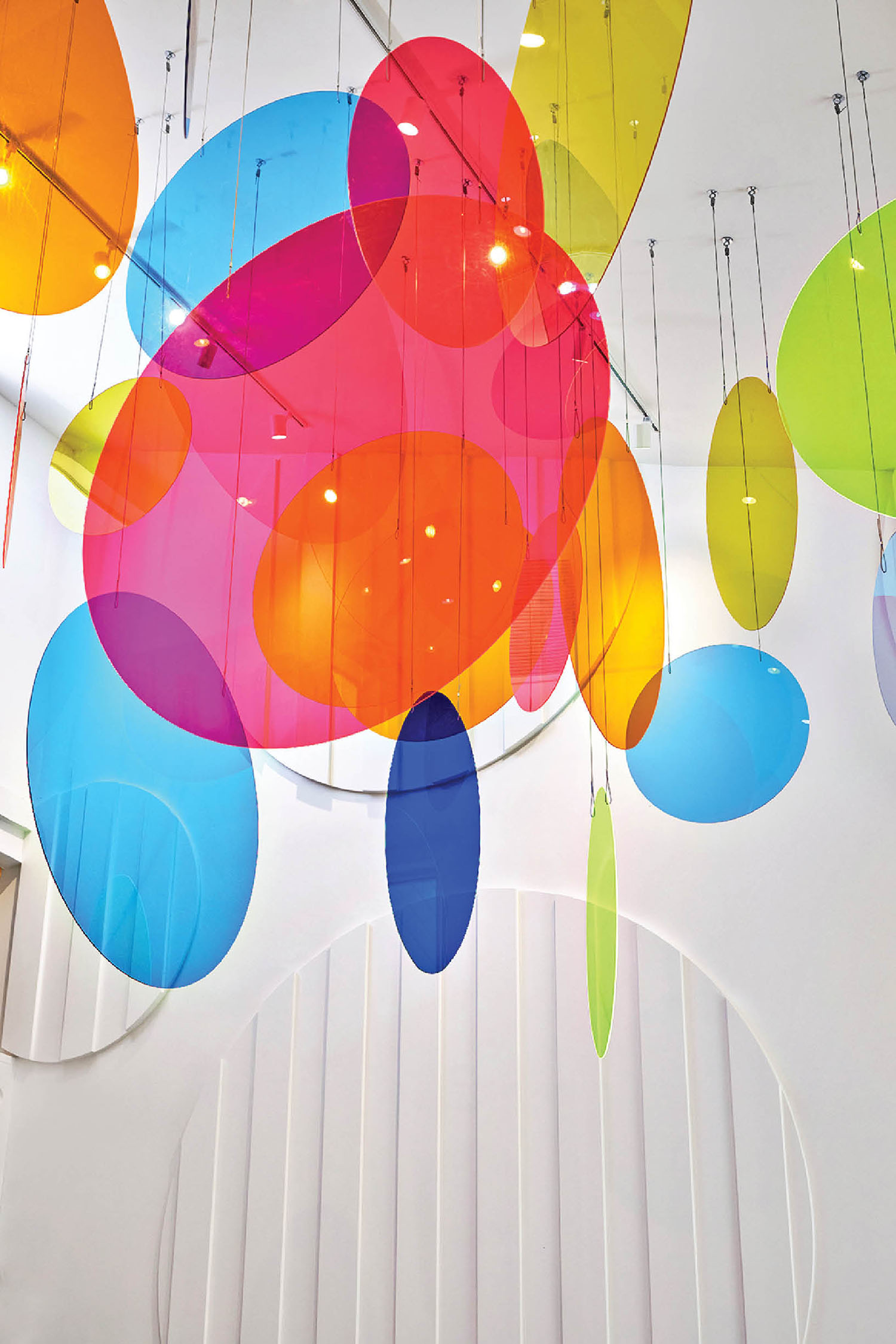 A colorful ceiling with many colorful balloons hanging from the