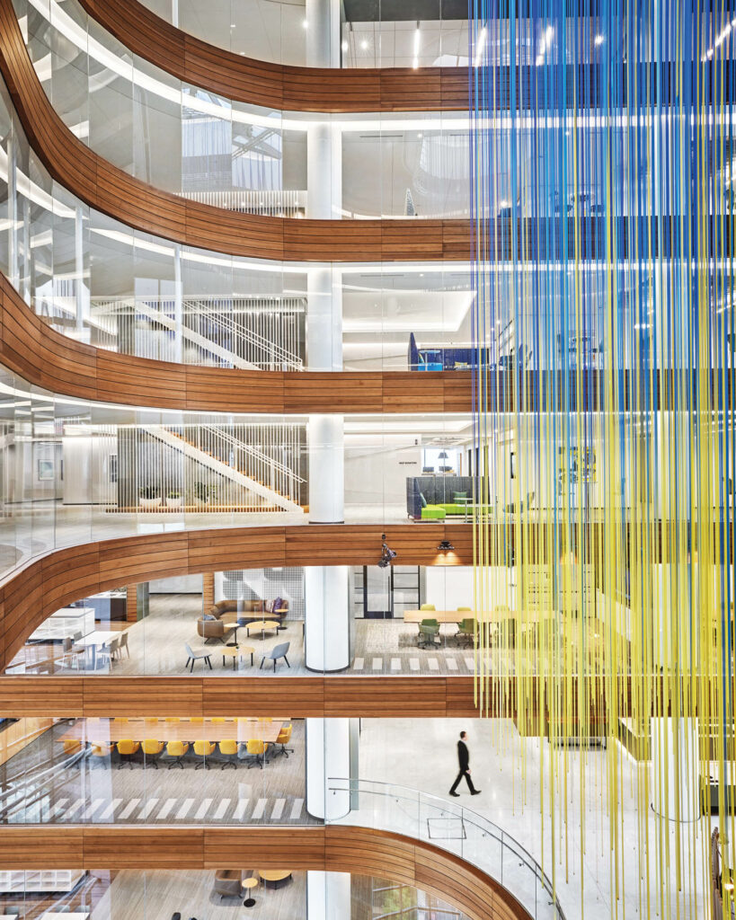 an art installation hangs from the ceiling with blue and yellow threads