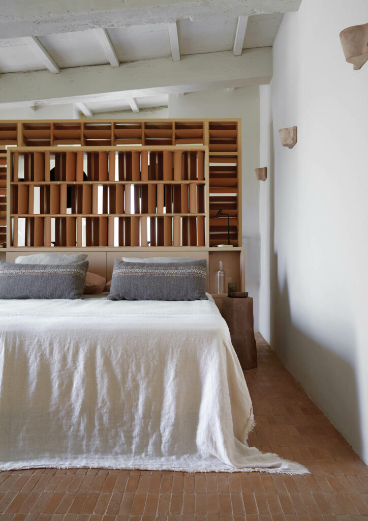 A terra-cotta screen separates a guest room from its bathroom.