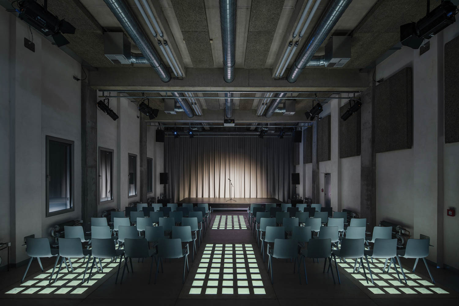 a stage with gray chairs in a row