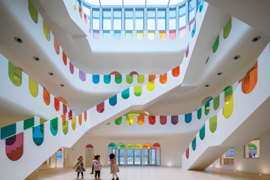 children in a room with rainbow staircase and skylight