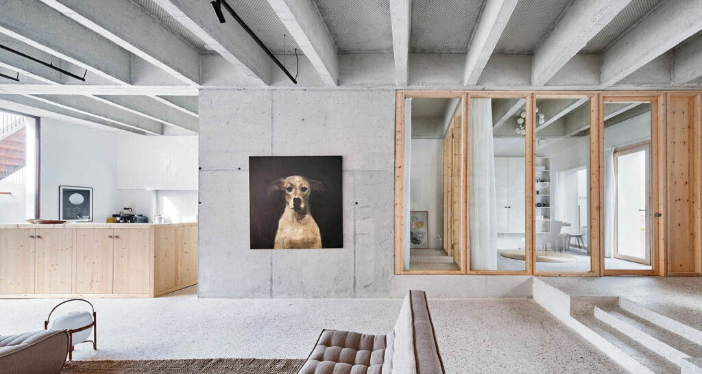 A living room with concrete walls and a large couch