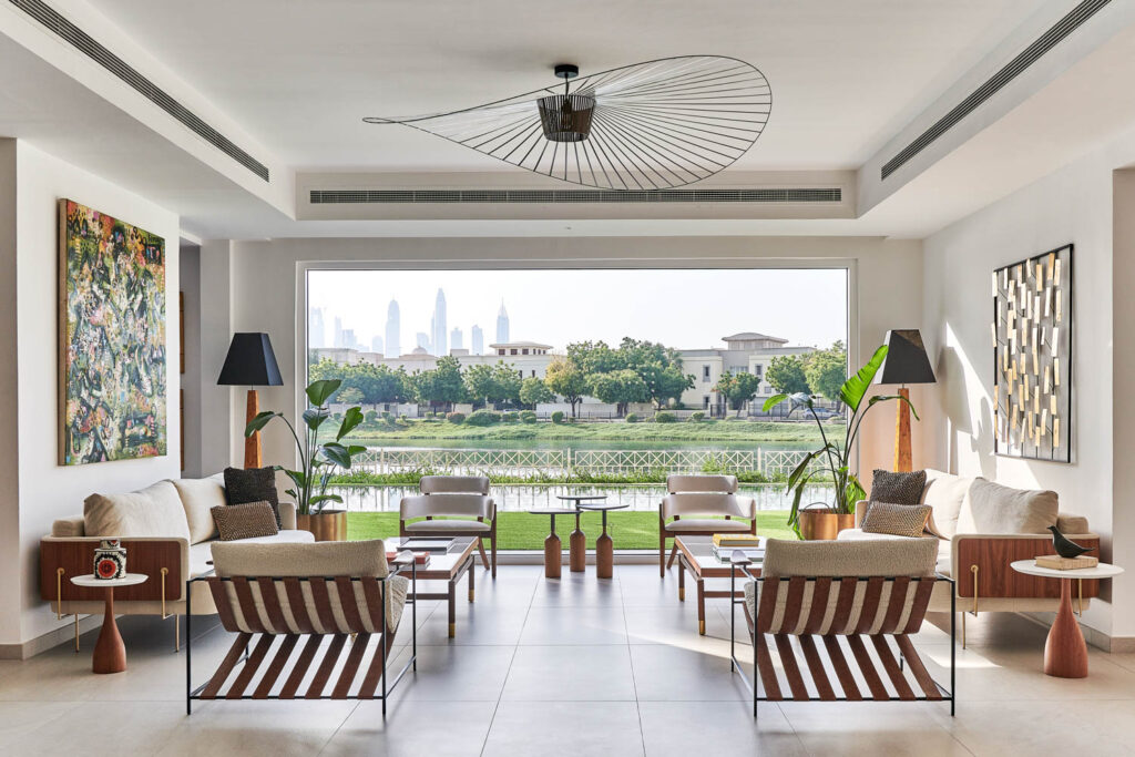 an indoor-outdoor living oom with white armchairs