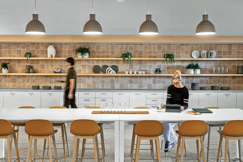 Nuro employees in a kitchen with white table and orange bar stools