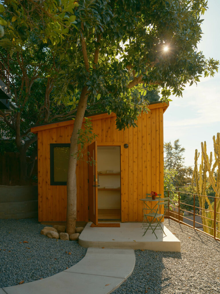 a small wooden house surrounded by cacti