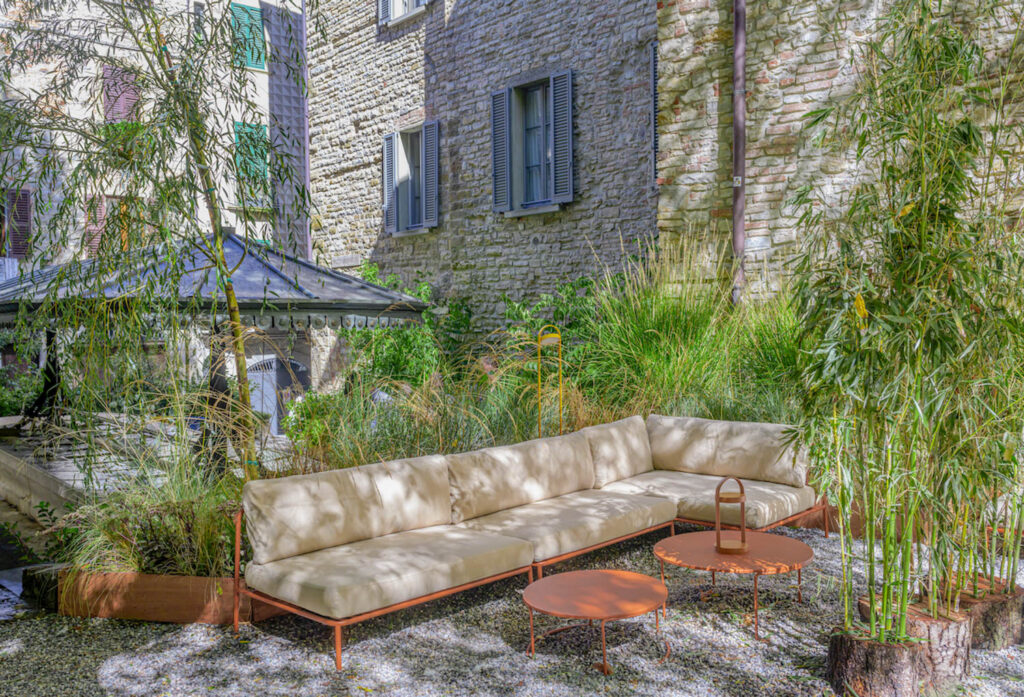 a cream sofa surrounded by greenery