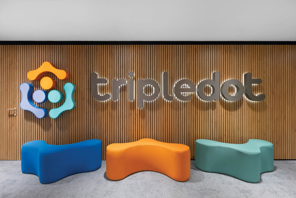 tripledot reception signage with blue and orange and green ottomans