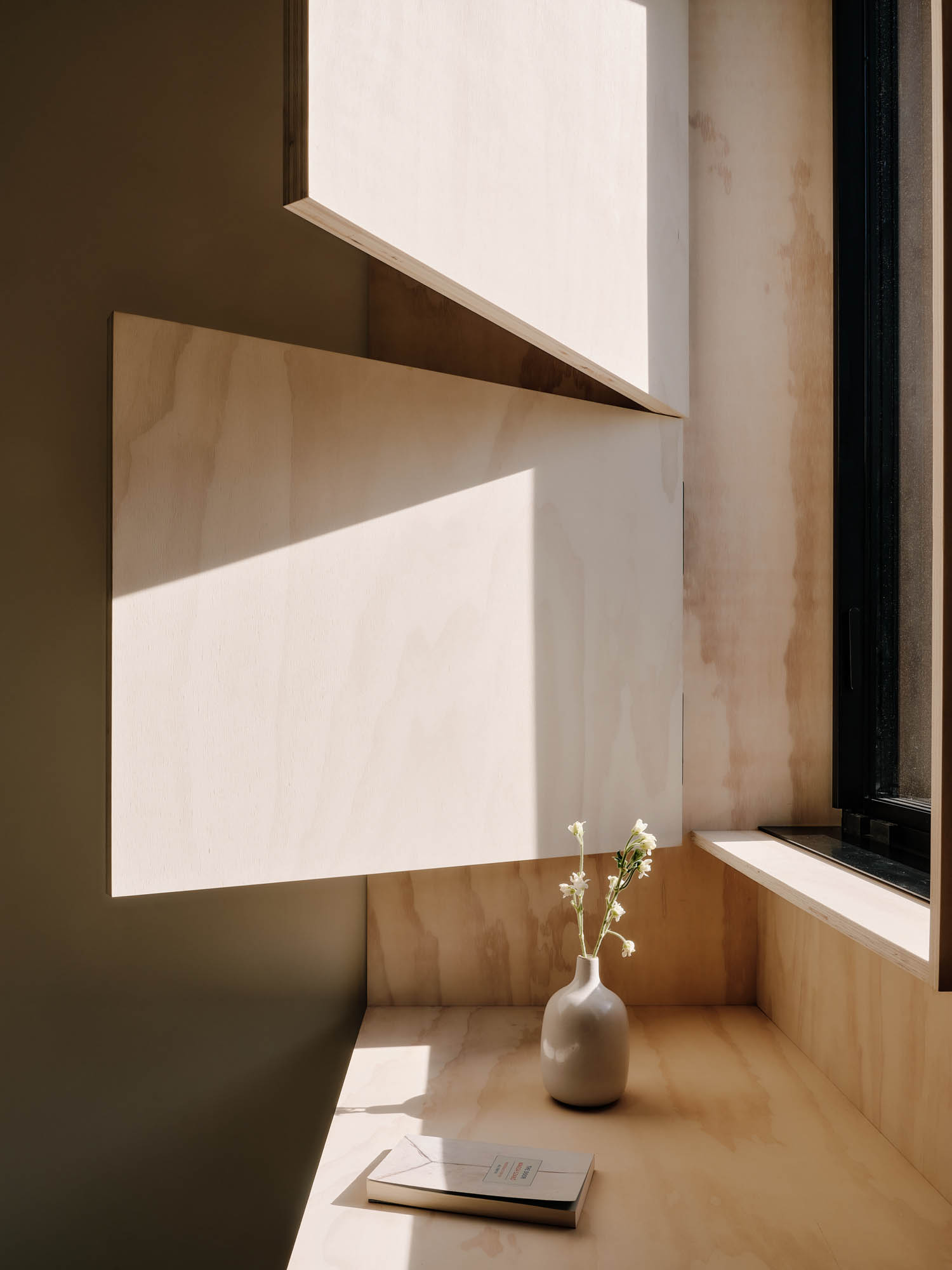 wooden desk underneath shutters letting in light