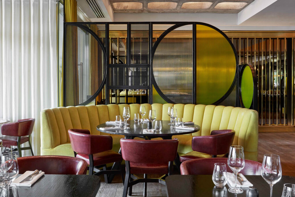 dining area with maroon velvet chairs and rounded yellow booth