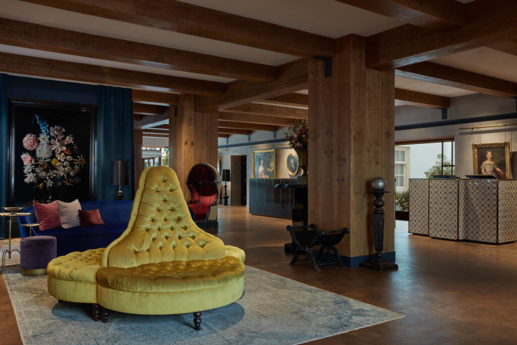 hotel lobby of Pulitzer Amsterdam with pointed yellow couch and wooden columns