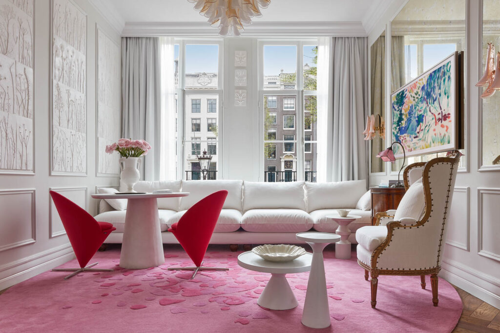 all-white room with matching drapes and sofa and bright pink carpet