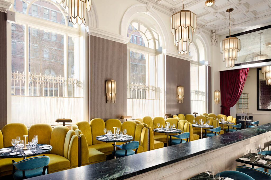 dining area with bright yellow couches and chandeliers