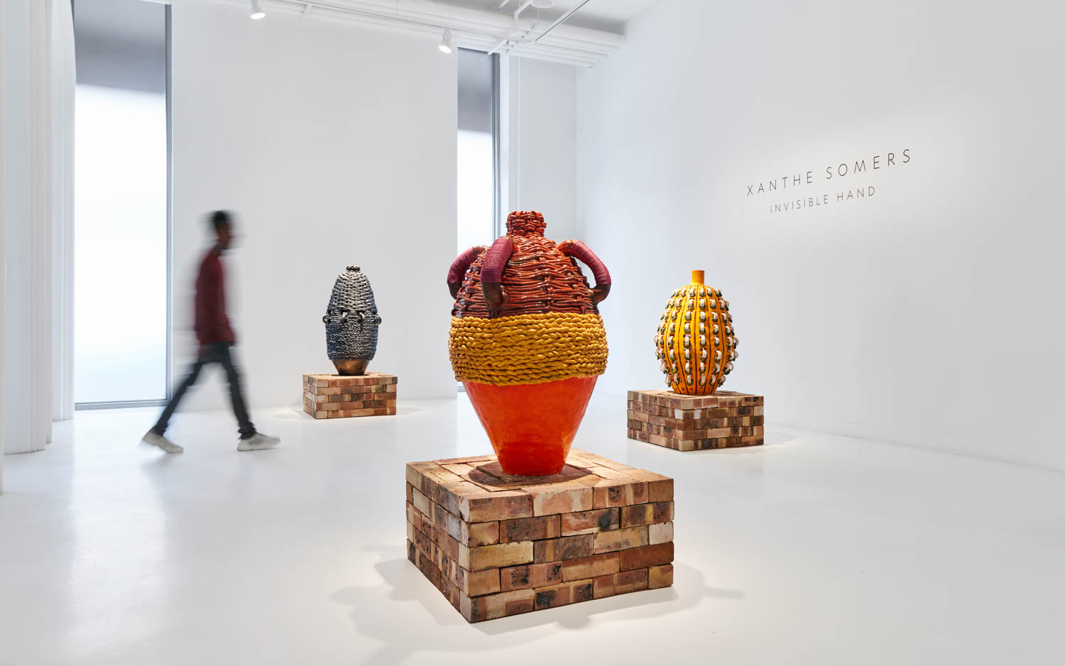 gallery exhibition space with three large vases