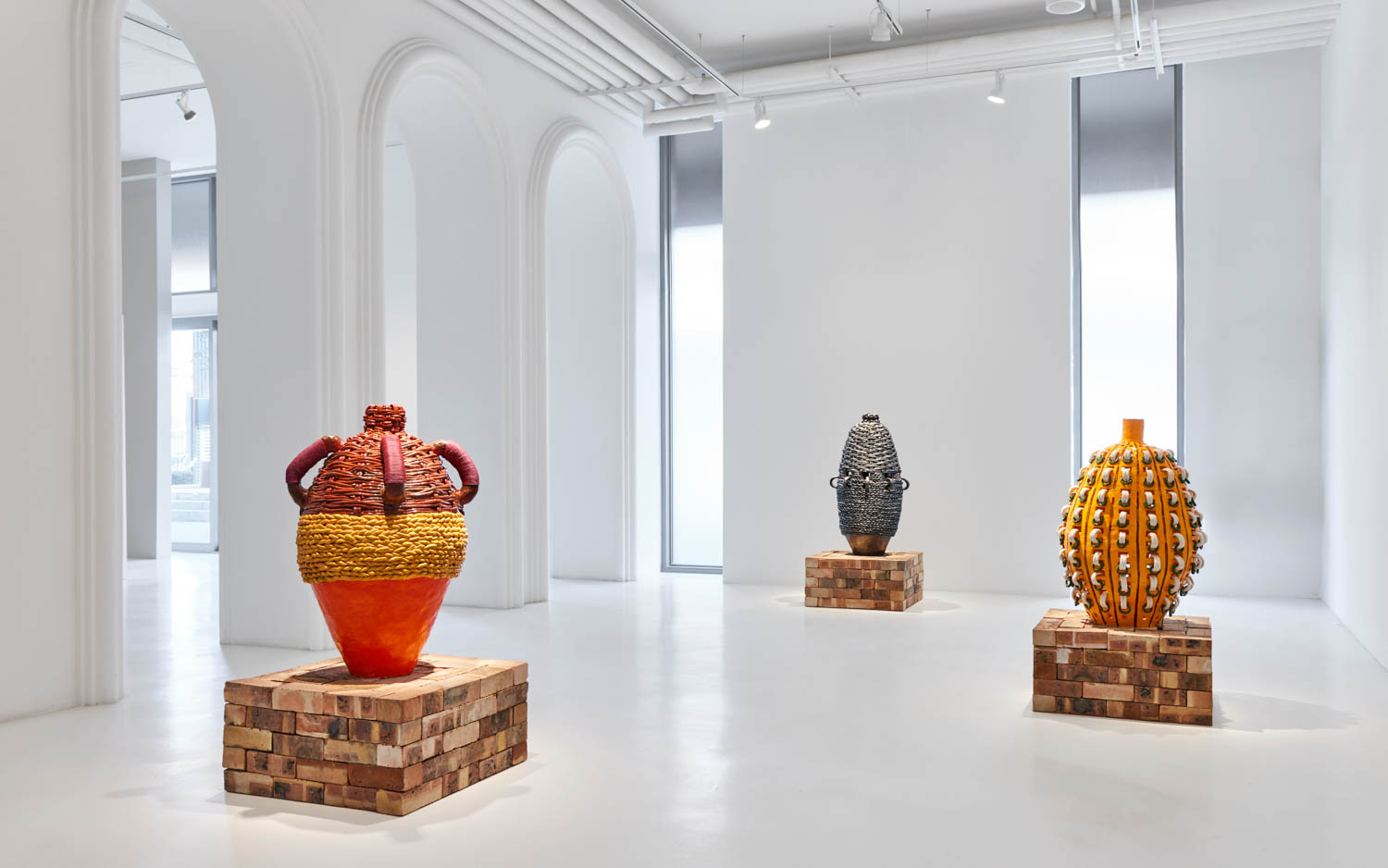 gallery exhibition space with three large vases