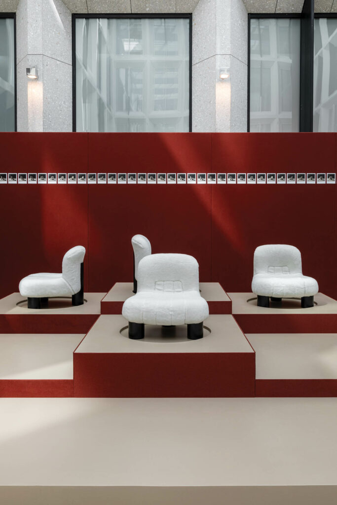 multiple white chairs against a red background