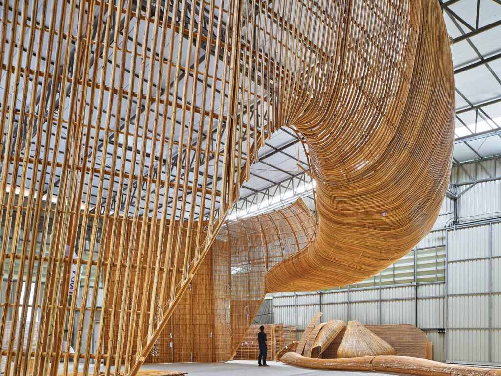 person standing under a curved rattan structure