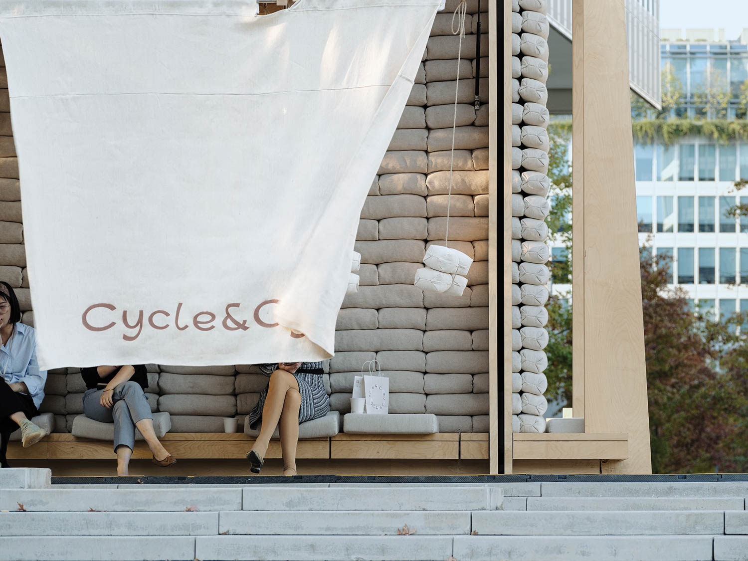 a large white curtain serves as shade for some outdoor seating