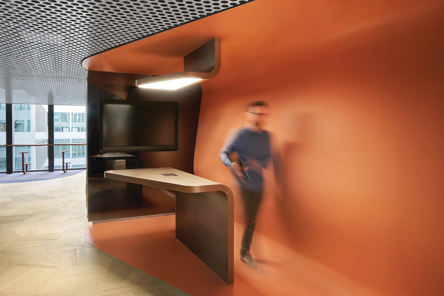 person working in an IT area with a bright orange backdrop