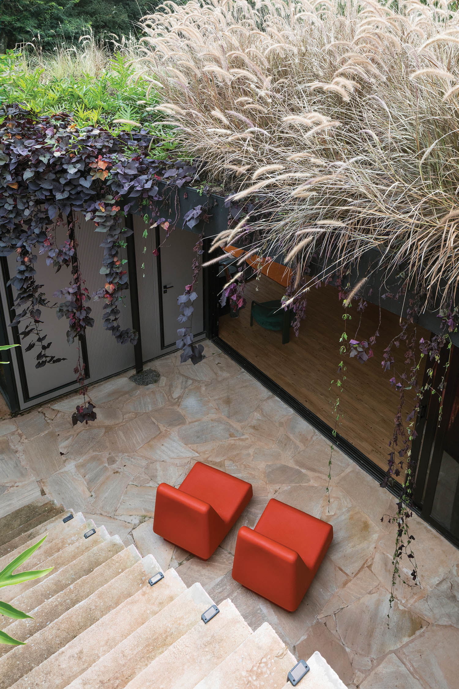 aerial view of the courtyard with bright red chairs and glass sliding doors