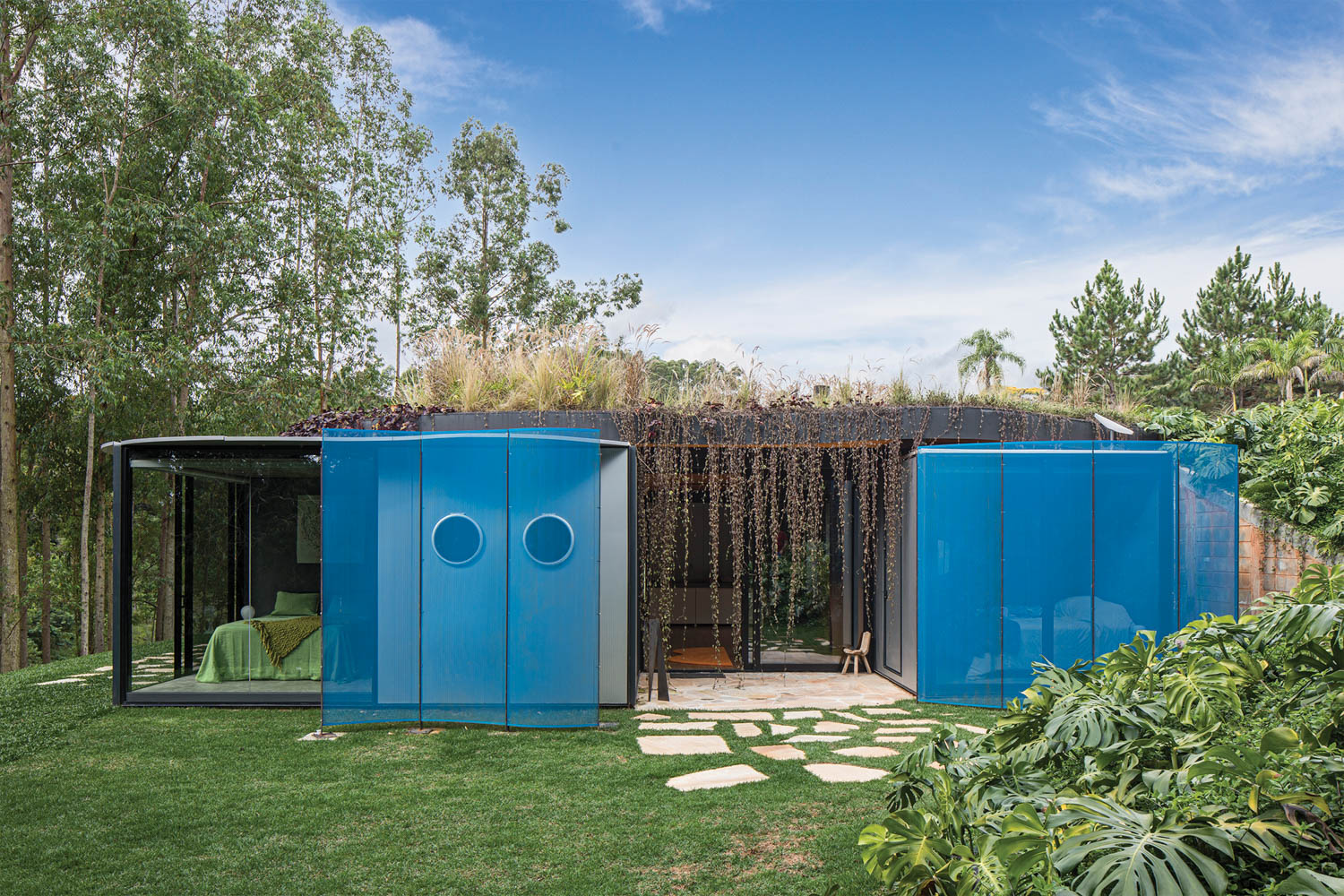 front of home with blue panels over the sliding doors and a planter on top of the modules