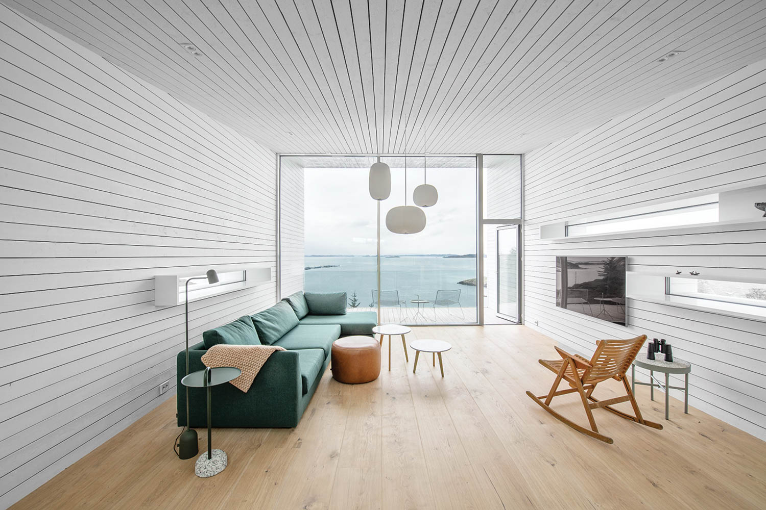 living room with white slatted ceiling, green couch and view to outside