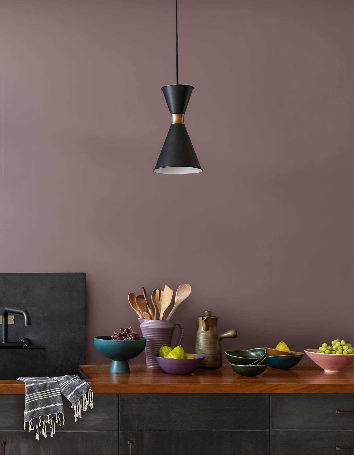 kitchen area with Cinnamon slate paint on walls, hanging black lamp and kitchen accessories