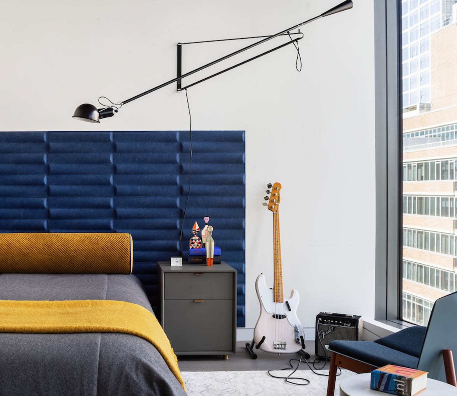 children's bedroom with blue headboard, white guitar and view of the city