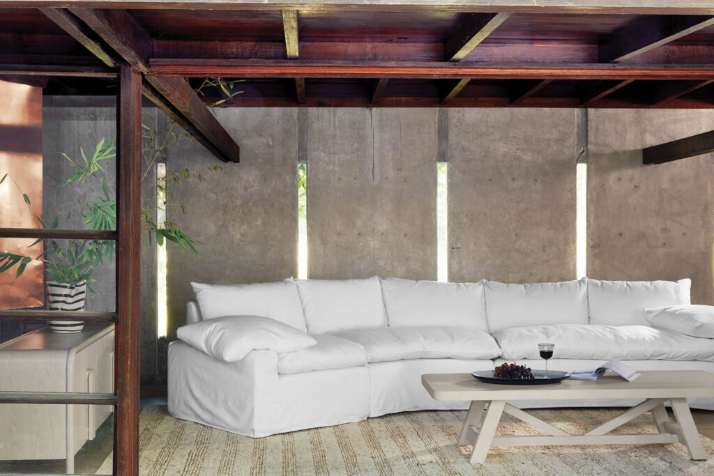 white couch in a room under a wooden beamed ceiling