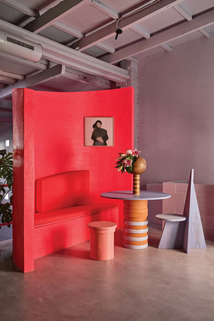 bright red dining nook with red chair and striped orange table