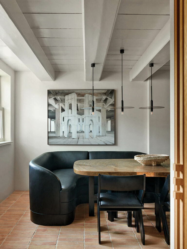 breakfast nook in corner of home with curved black sofa