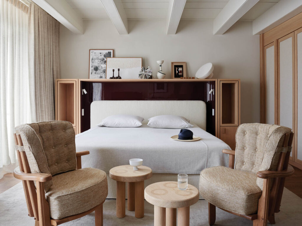 bedroom with white bed and two chairs