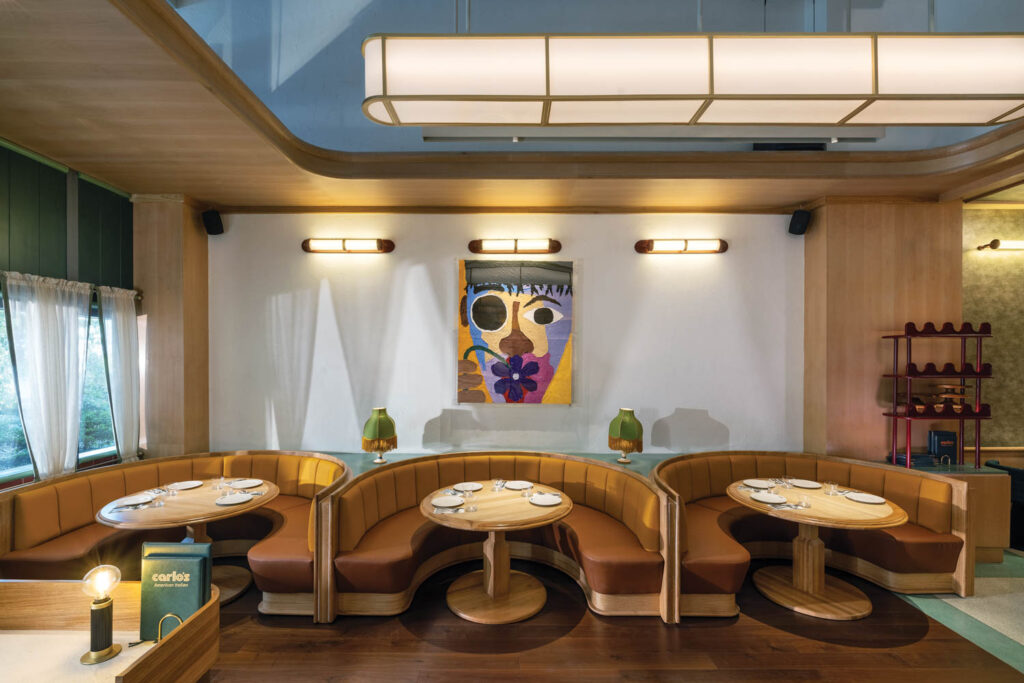 dining area with curved tan booth and abstract artwork