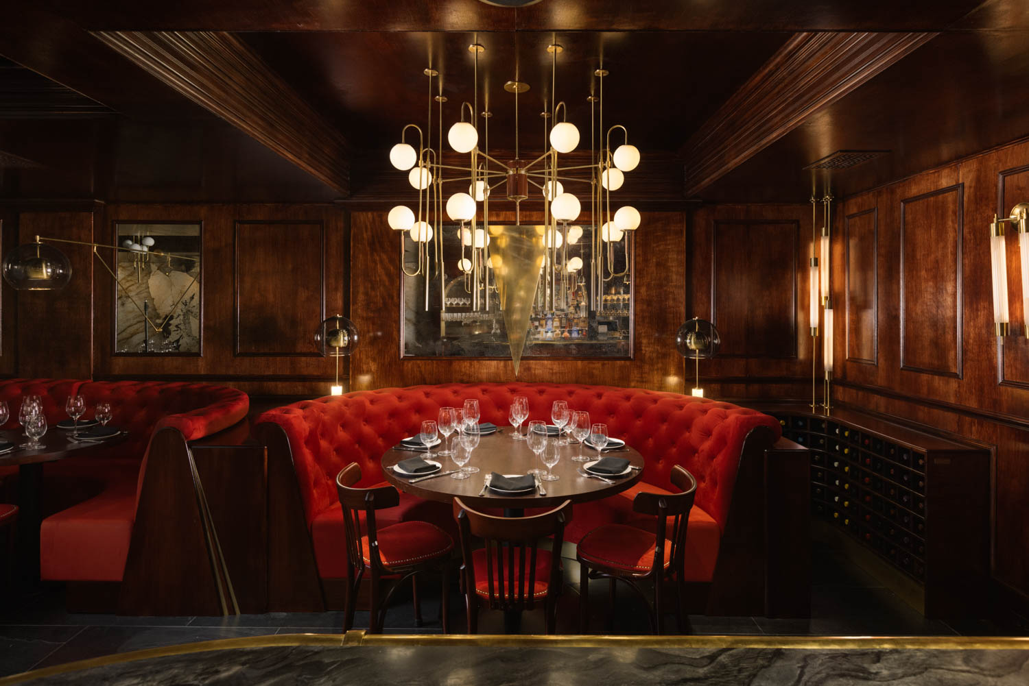 chandelier hanging above dining area with red banquette