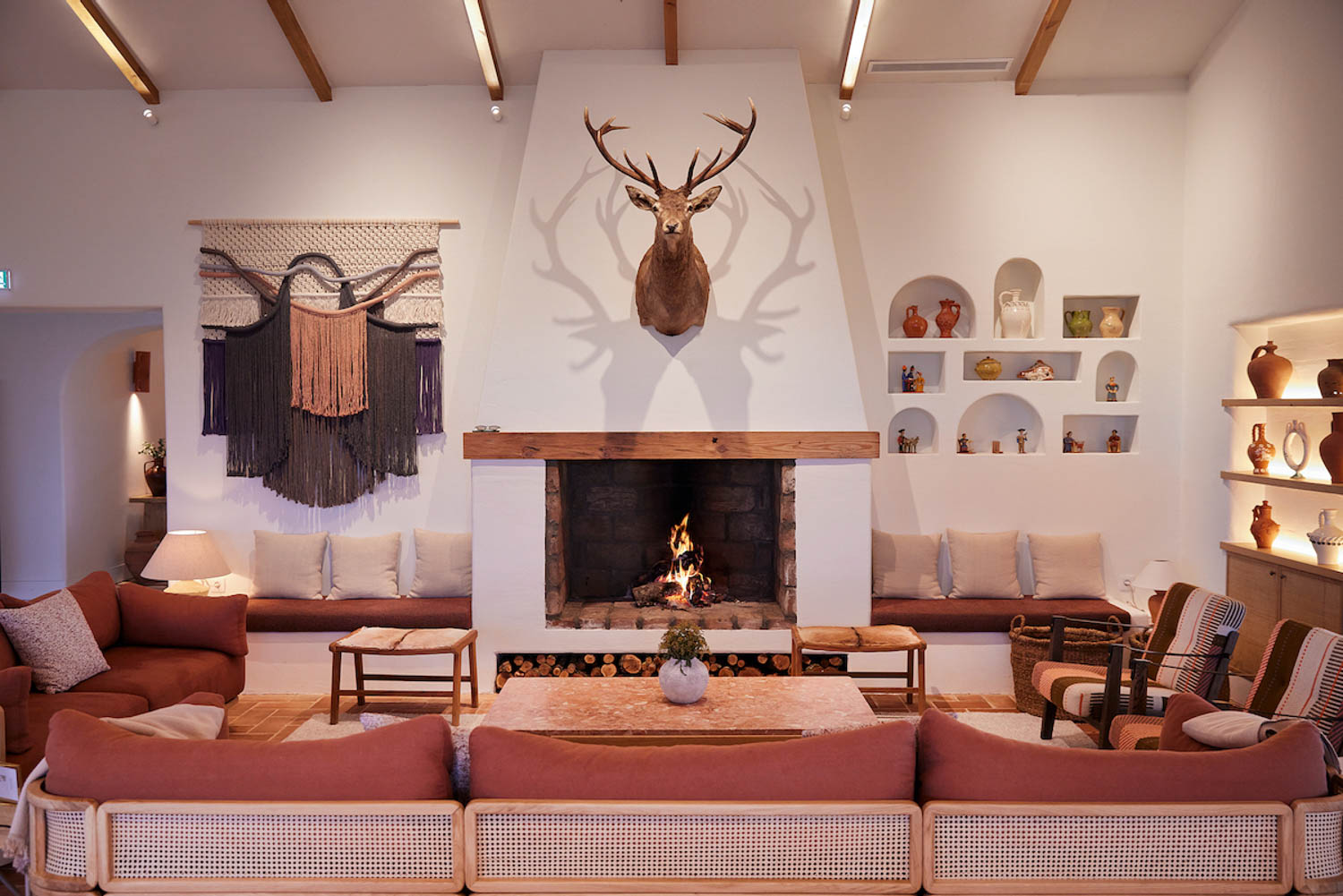 living room with white fireplace, orange sofa and deer head