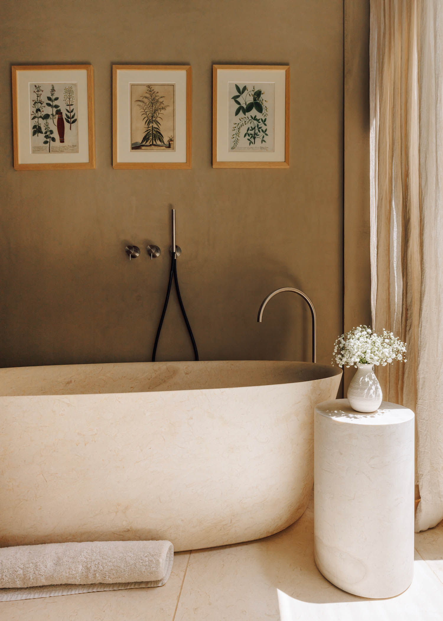 white bathtub with artwork hanging above