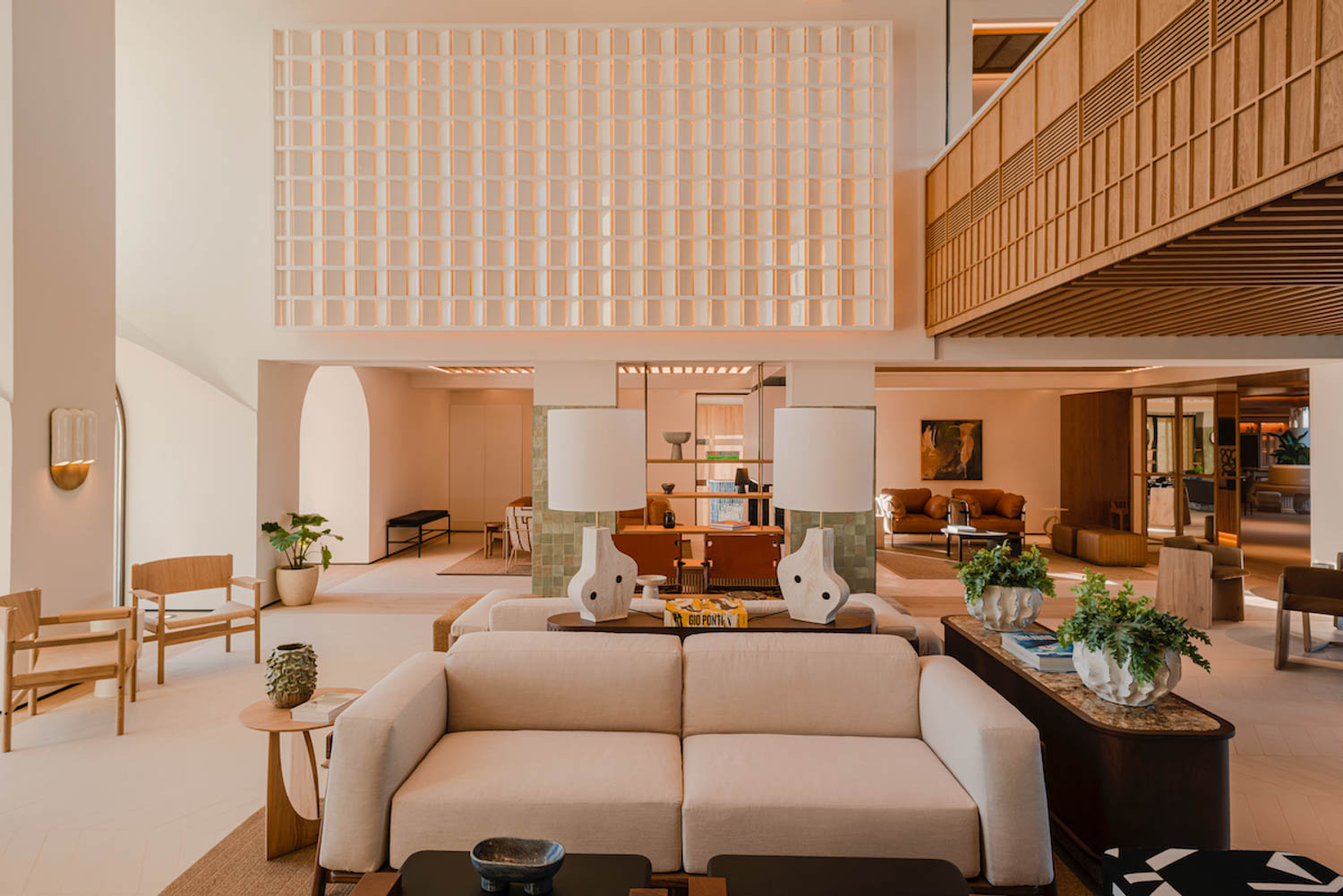 the lobby of the hotel with white sofas, plenty of seating and lots of light