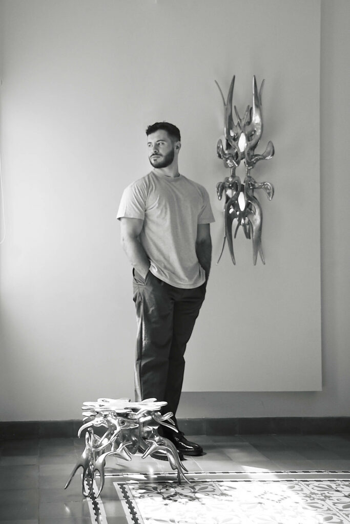 designer standing near his sculpture